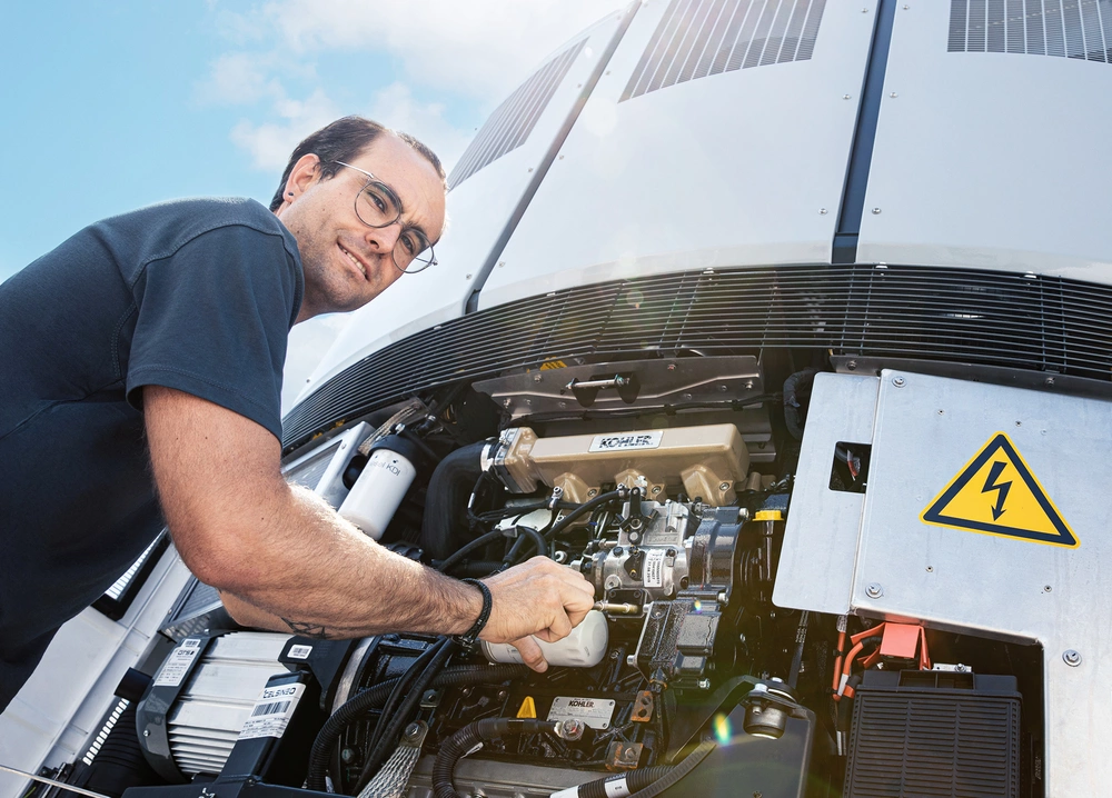 [Translate to English:] Servicetechniker arbeitet am Kühlaggregat 